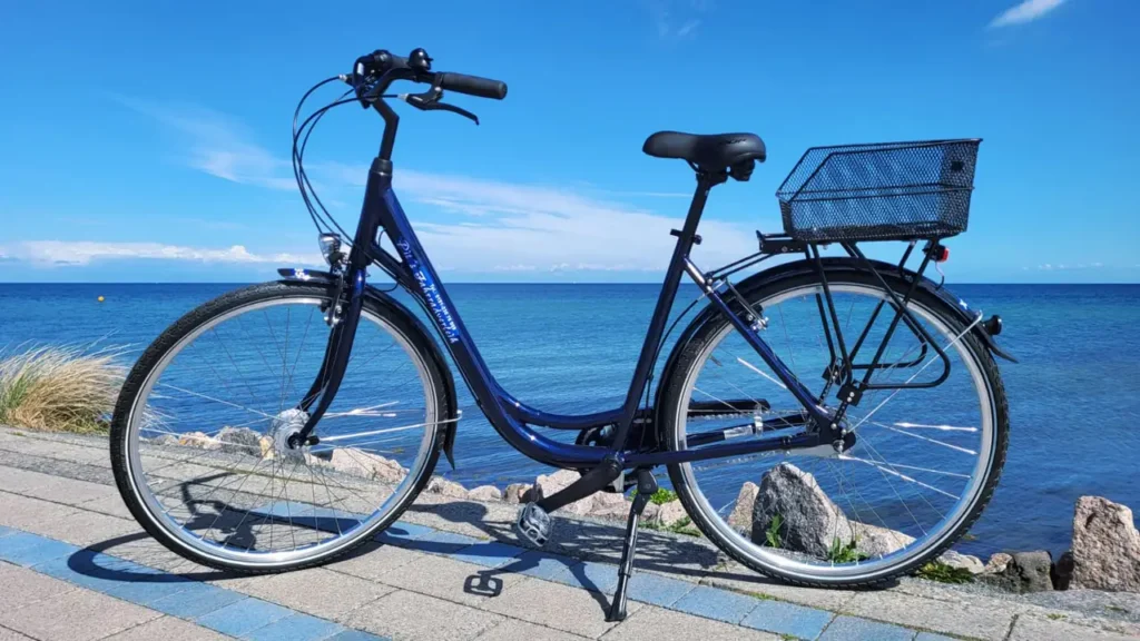 Blaues City-Rad mit Korb an der Ostsee